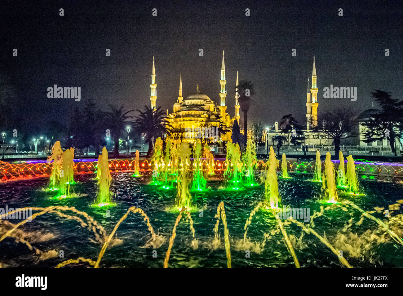 Colorful lights shine through a large fountain in front of the Sultan ...