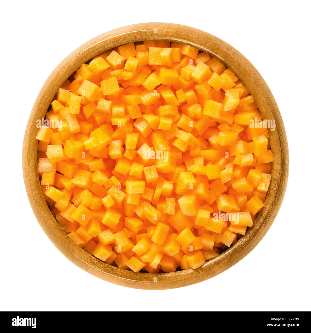 Carrot cubes in wooden bowl. Fresh cut crisp pieces of Daucus carota, a root vegetable with orange color. Edible taproot. Isolated macro food photo. Stock Photo