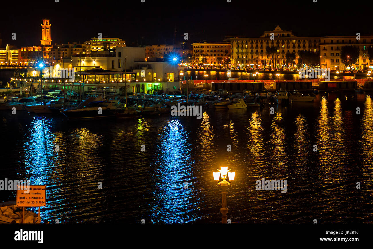 Bari night seafront and city lights. The sign is shown: 'prohibition on pickup seawater. Board of Ordinance n.8951 of 06/30/1984' Stock Photo