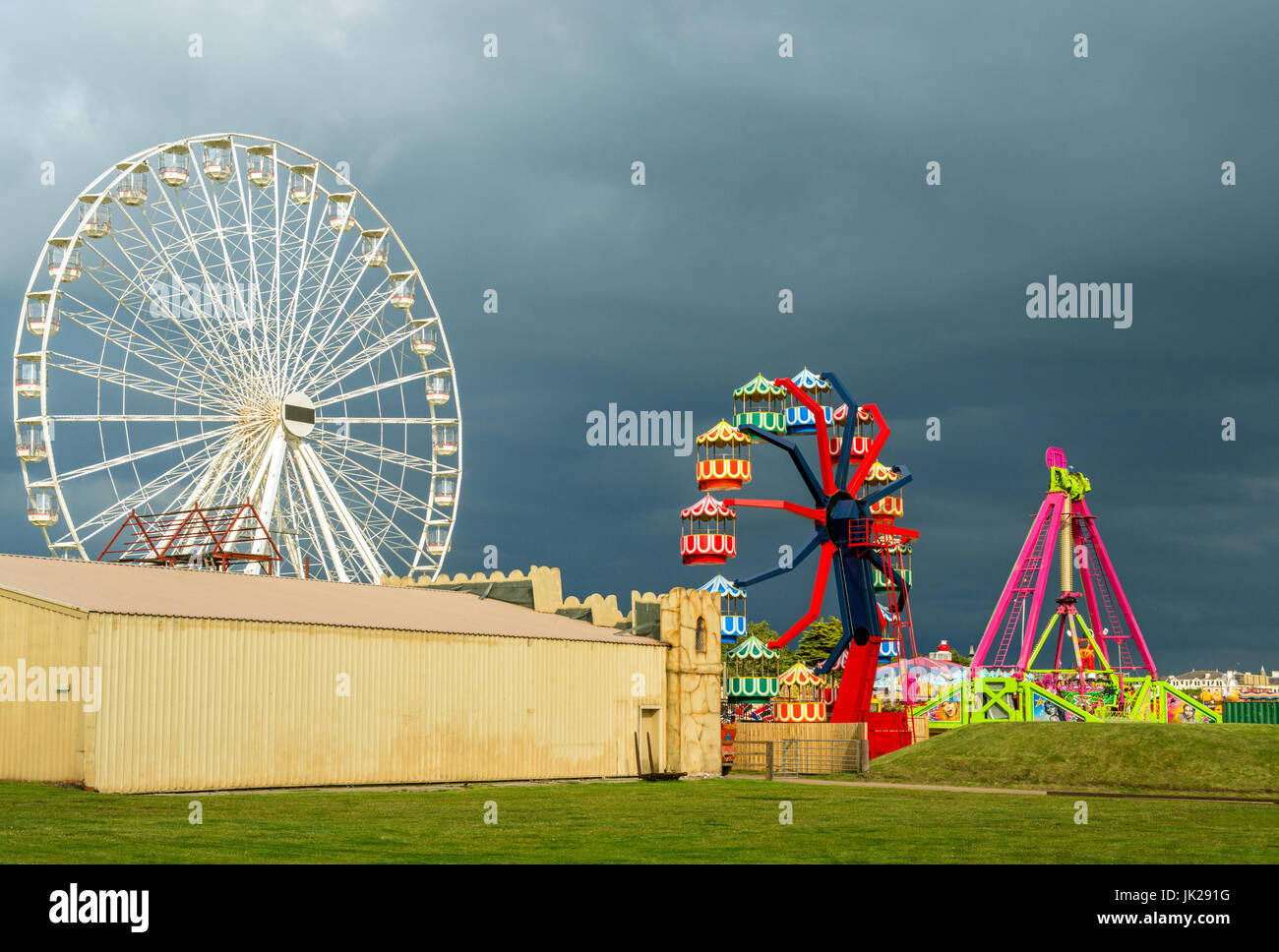 Southport Funfair against a black sky and lit by the sun, Lancashire Stock Photo