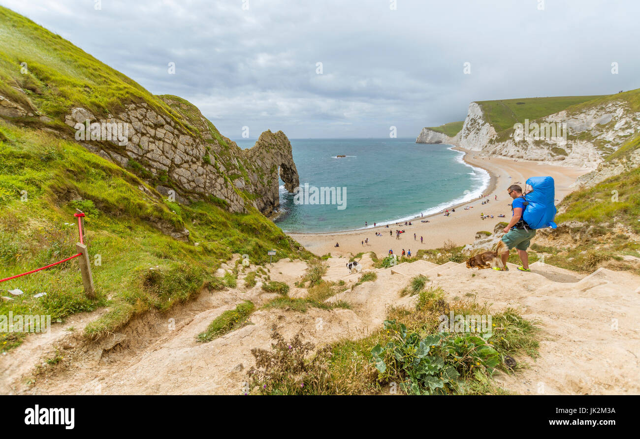 A tourist descends the steps to Durdle Door at West Lulworth in Dorset Stock Photo