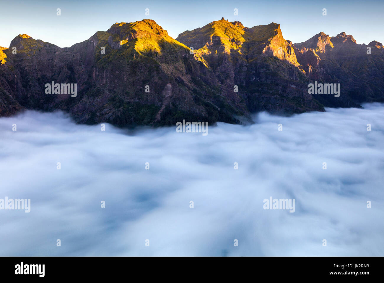 Mountain peaks shined by the sun over the clouds Stock Photo - Alamy