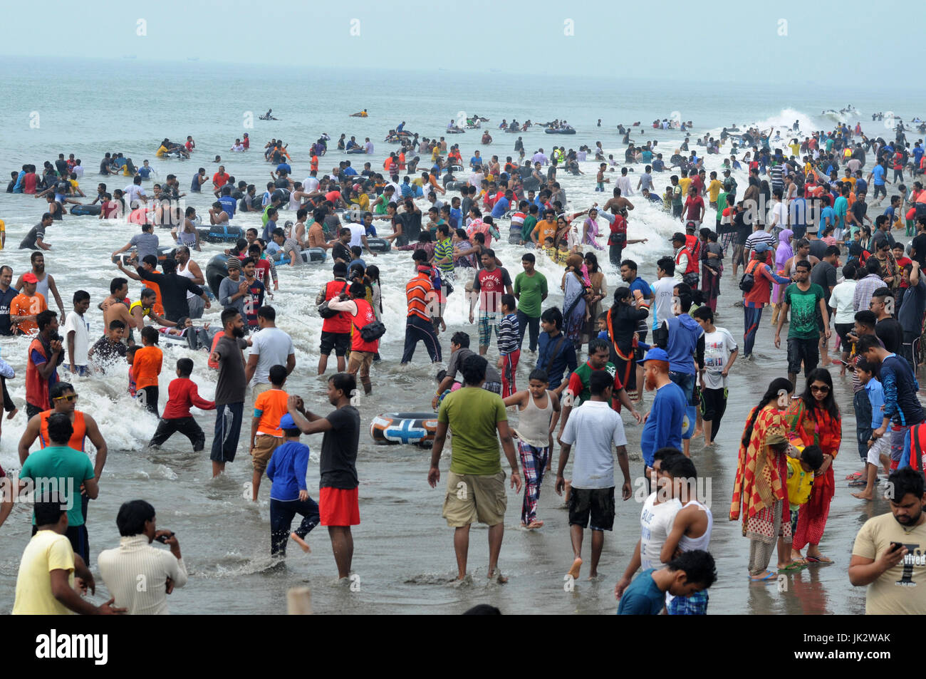 Thousands of people gathered at Cox’s Bazar sea beach to pass their vacation. The beach in Cox's Bazar is an unbroken 120 km (75 mi) sandy sea beach w Stock Photo