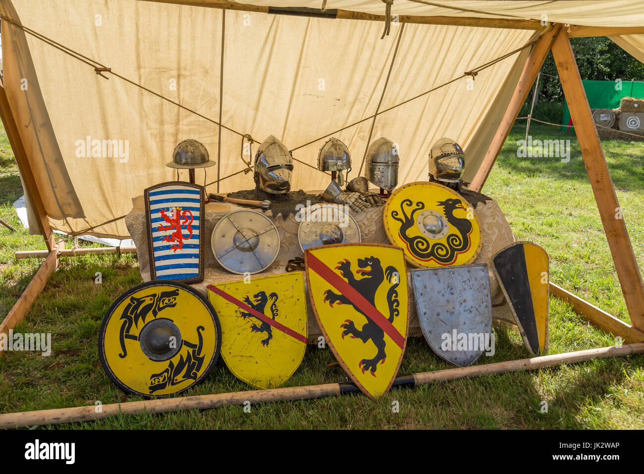 Colorful round shields, conical helmets displayed on medieval summer festival. Stock Photo
