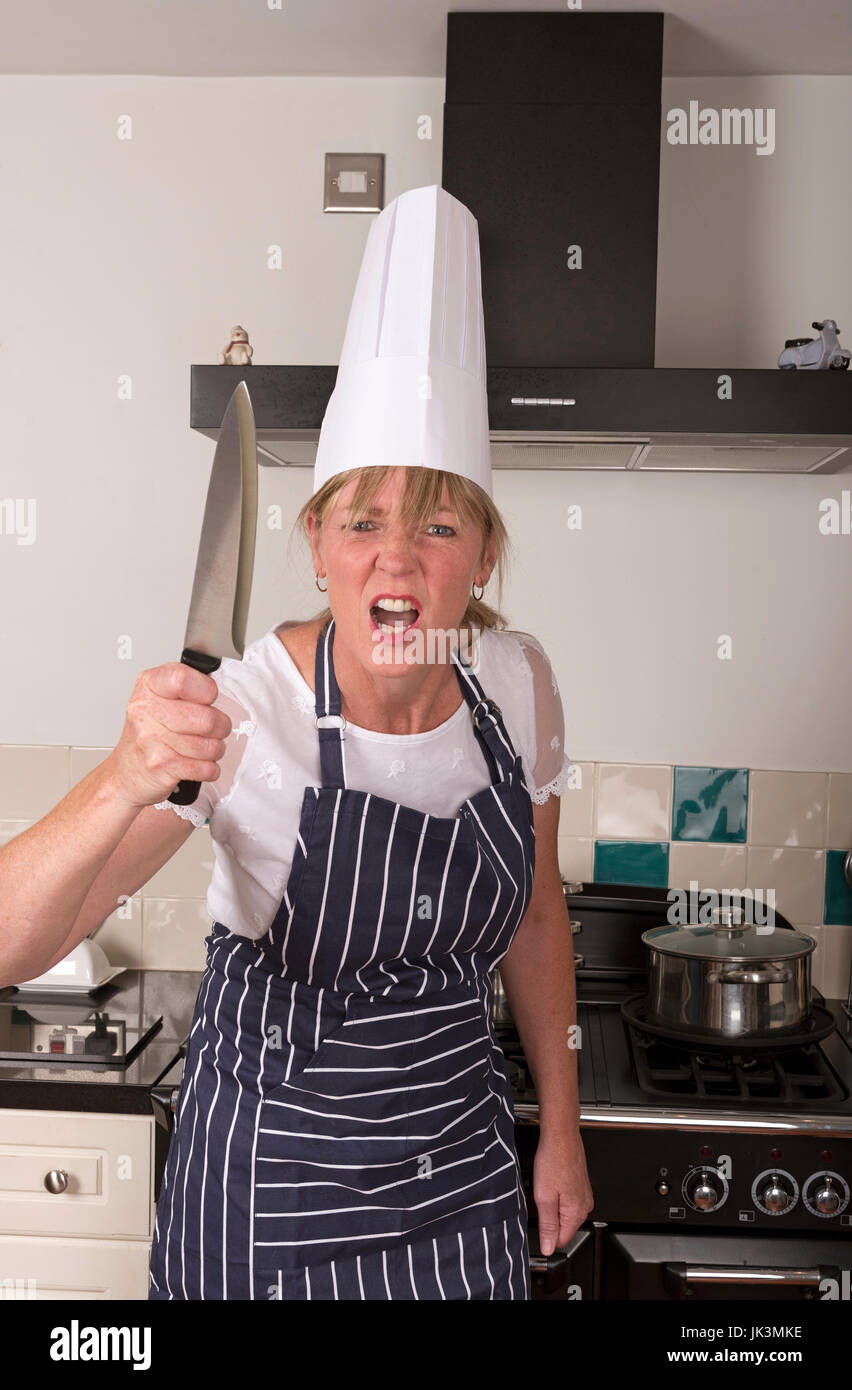 Portrait of a very angry chef holding a sharp kitchen knife in a