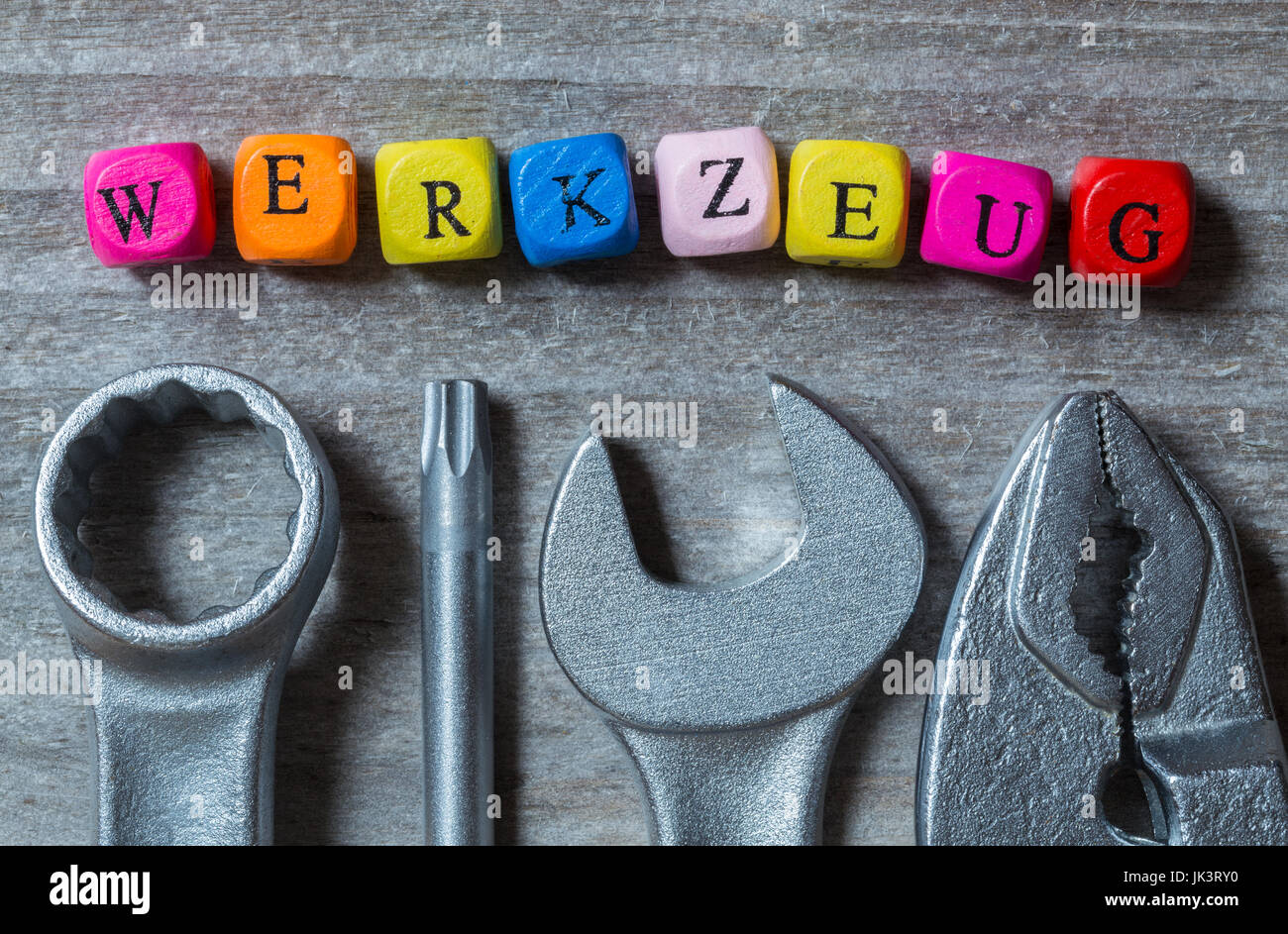 Werkzeug (in german Tool) letter cube and tool on gray wood visualization. Stock Photo