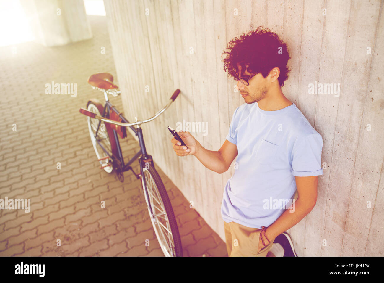 man with smartphone and fixed gear bike on street Stock Photo