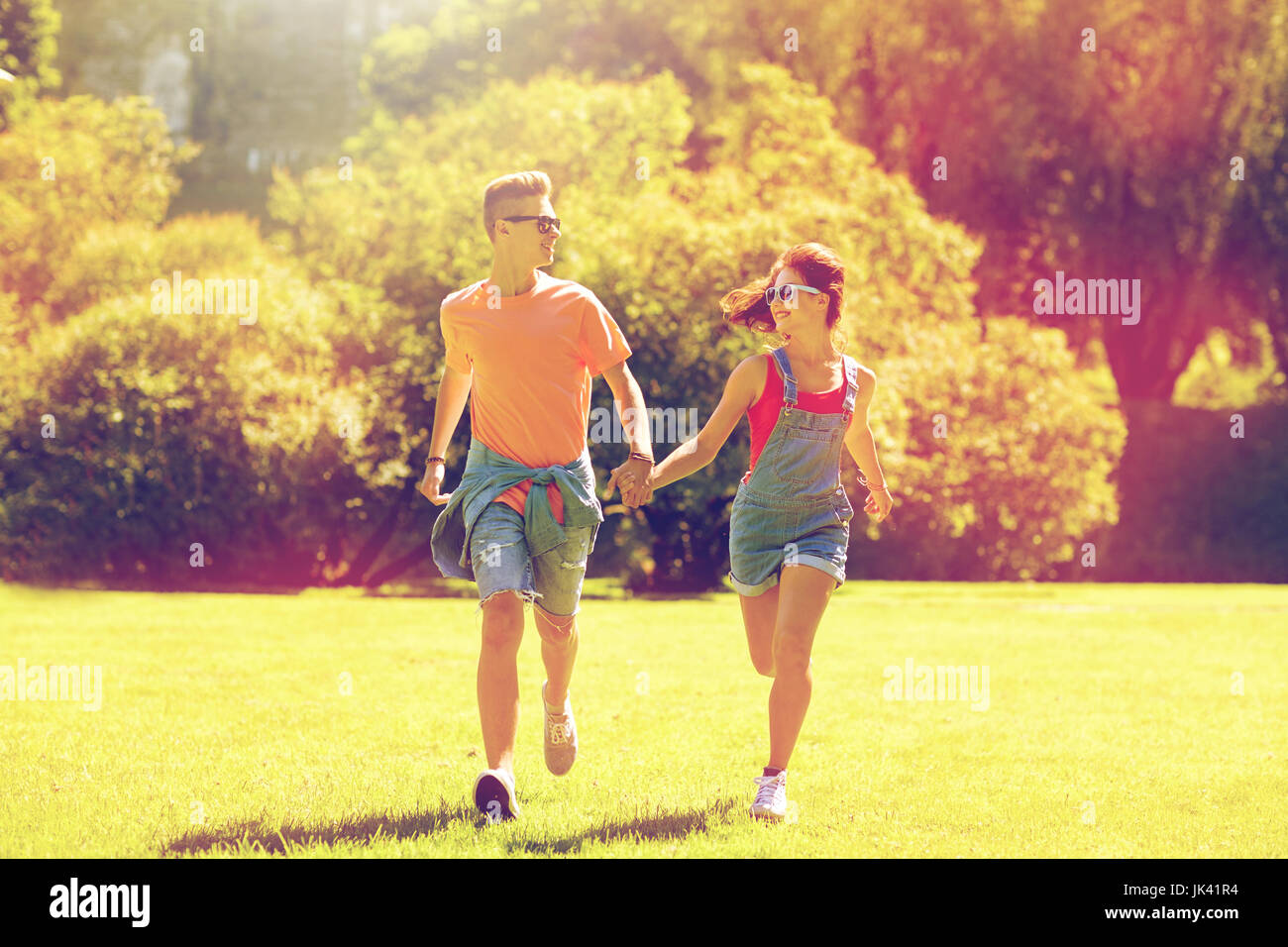 happy teenage couple running at summer park Stock Photo