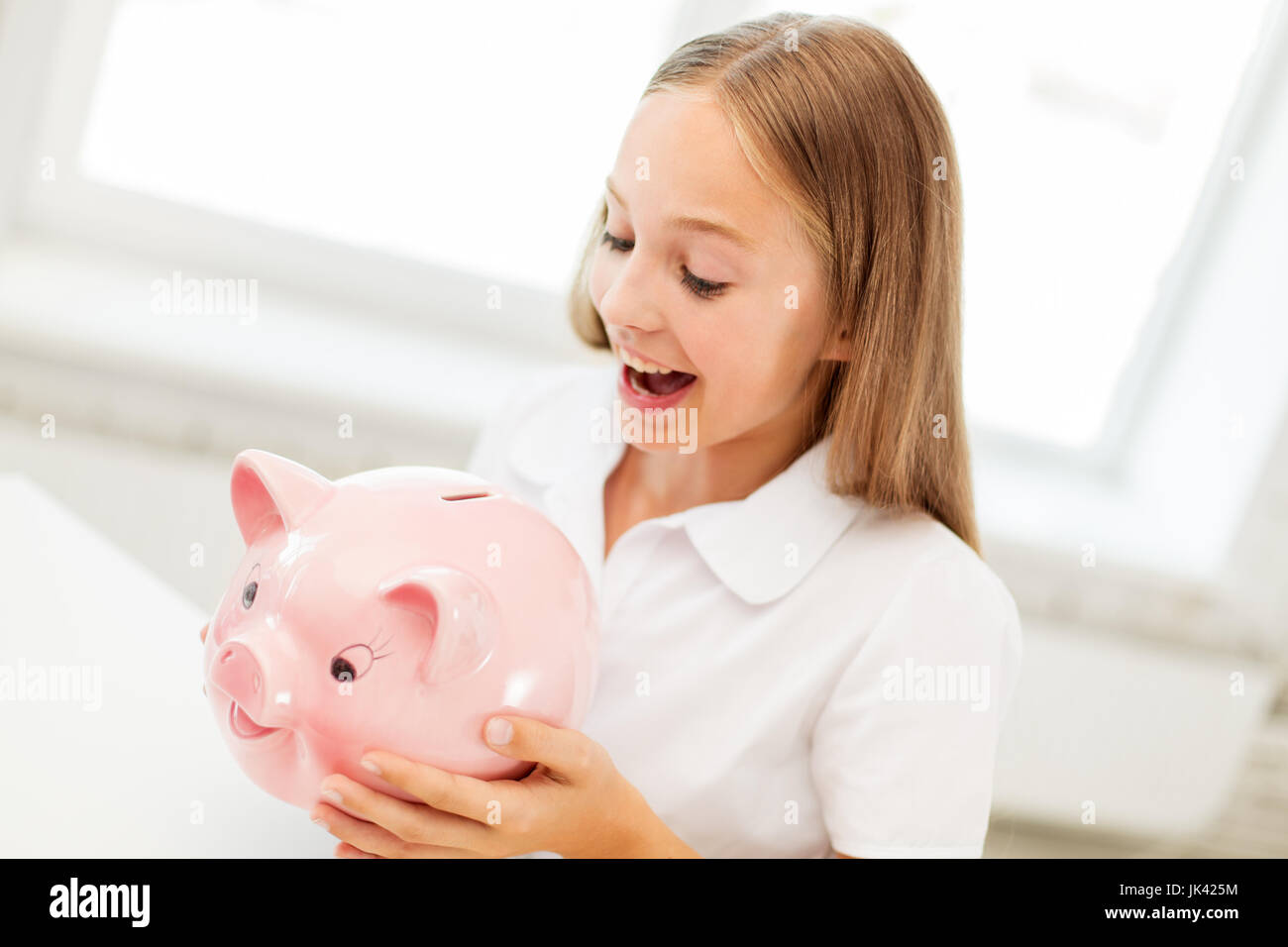 happy girl with piggy bank at home Stock Photo - Alamy