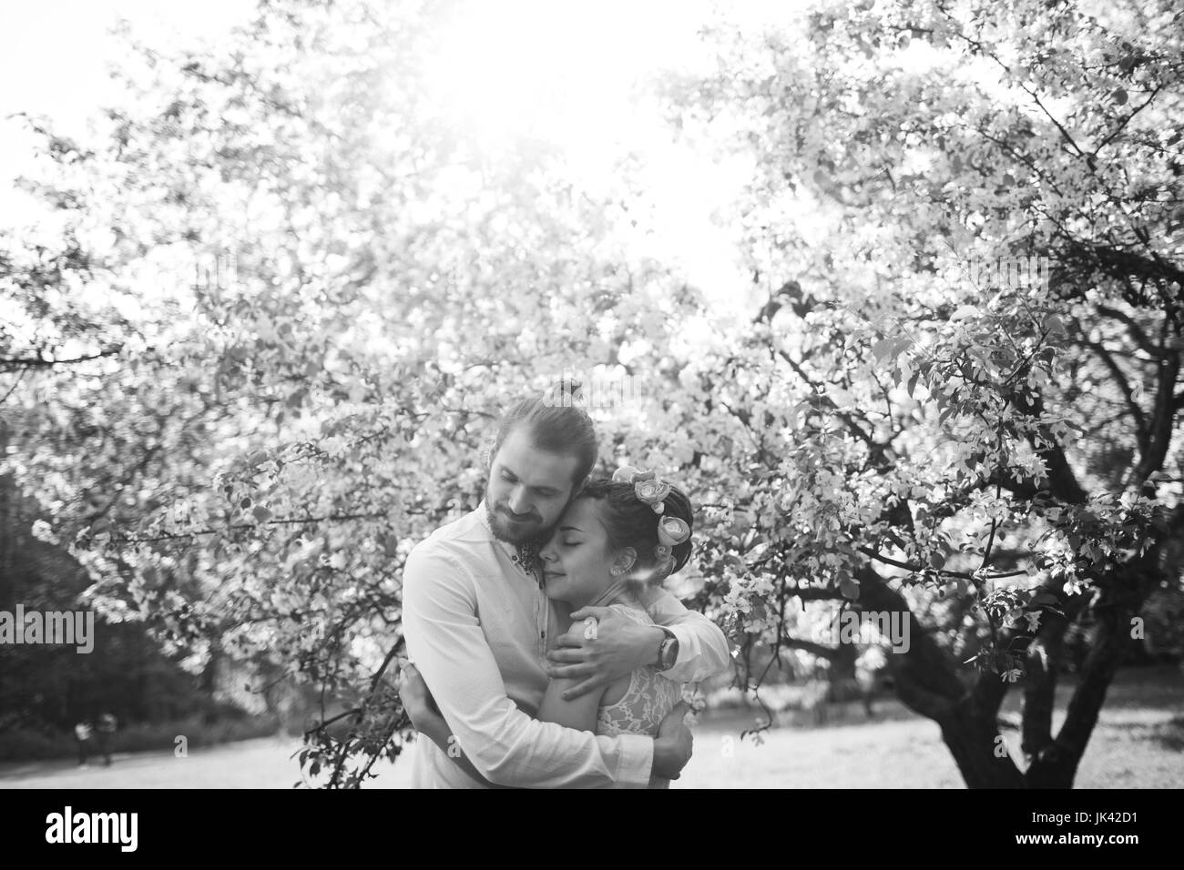 Middle Eastern couple hugging under flowering tree Stock Photo
