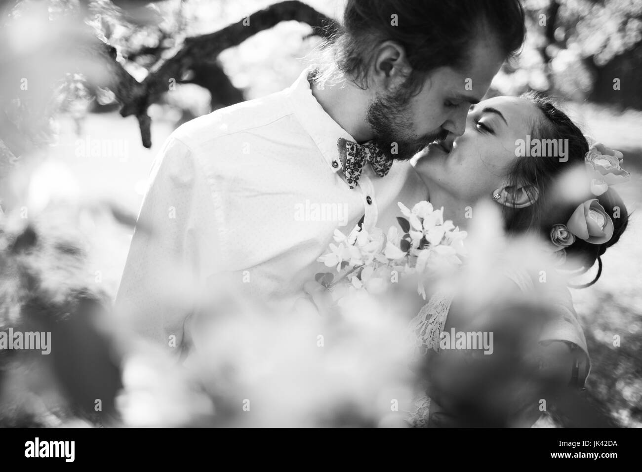 Middle Eastern couple kissing near flowers Stock Photo