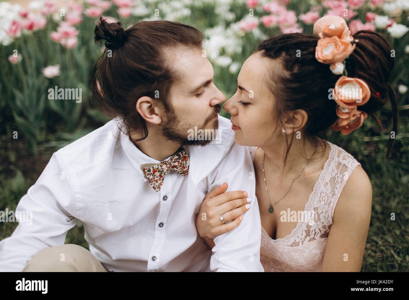 Middle Eastern couple hugging near flowers Stock Photo