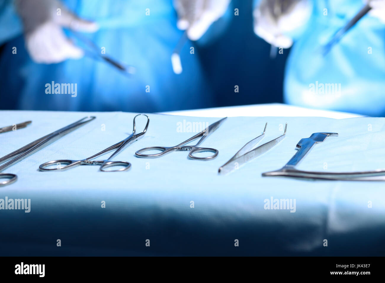 Surgical tools lying on the table while group of surgeons at background