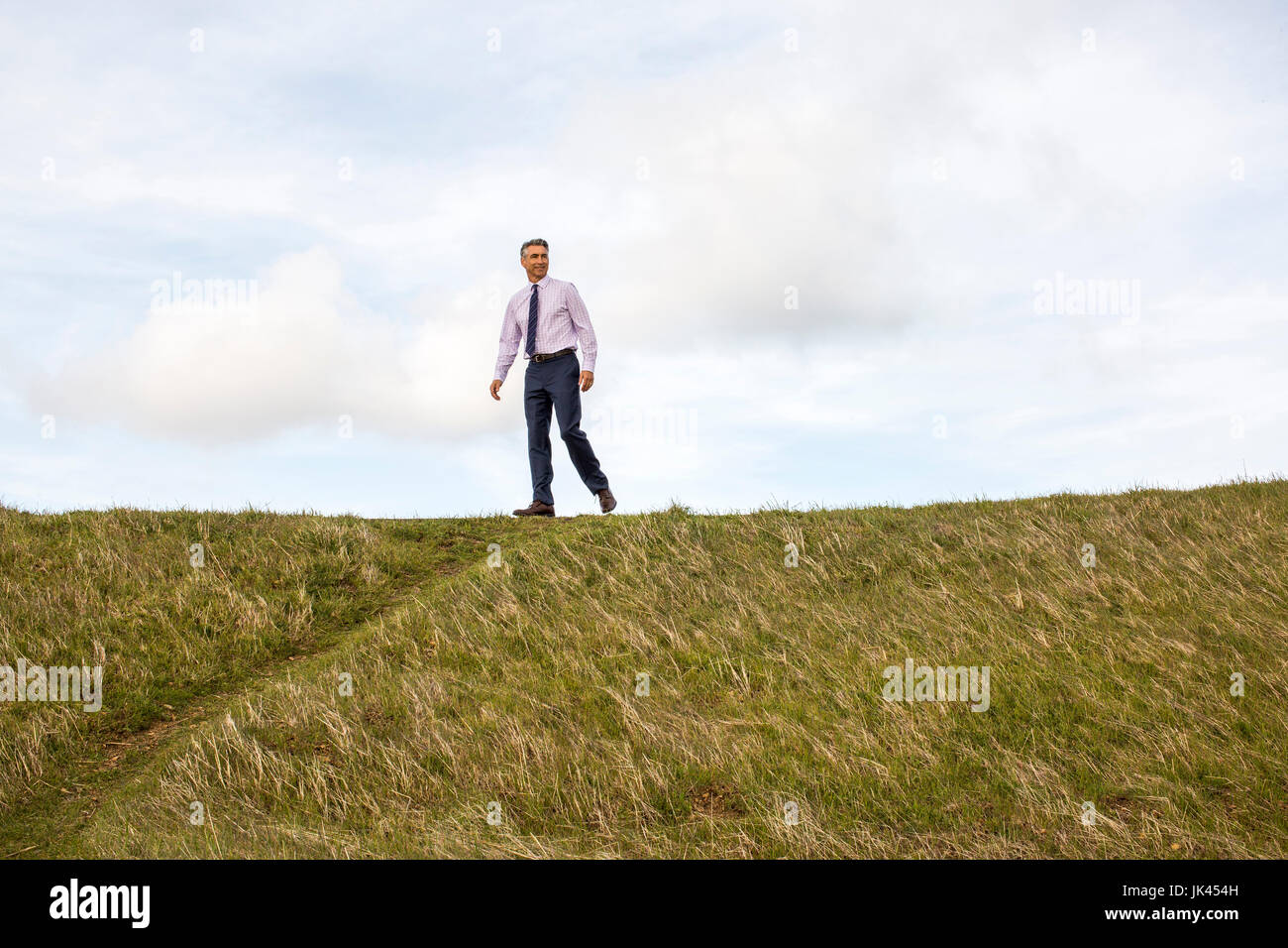 Caucasian businessman walking on hill Stock Photo