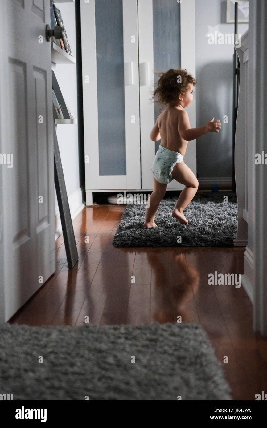 Caucasian boy wearing diaper running in corridor Stock Photo Alamy