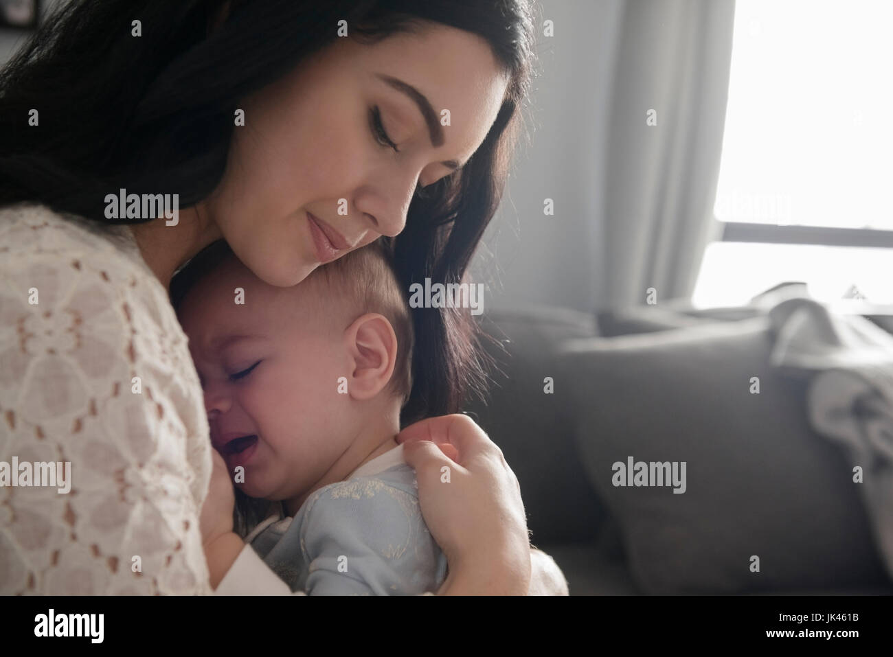 Caucasian mother comforting crying baby son Stock Photo