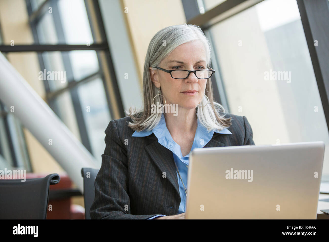 Serious Caucasian businesswoman using laptop Stock Photo