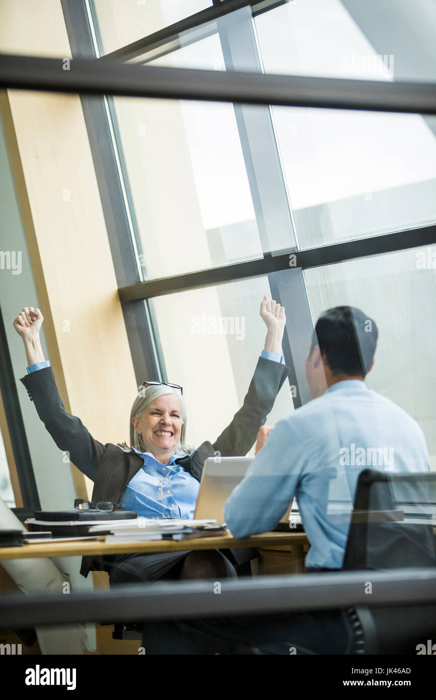 Business people celebrating in meeting Stock Photo