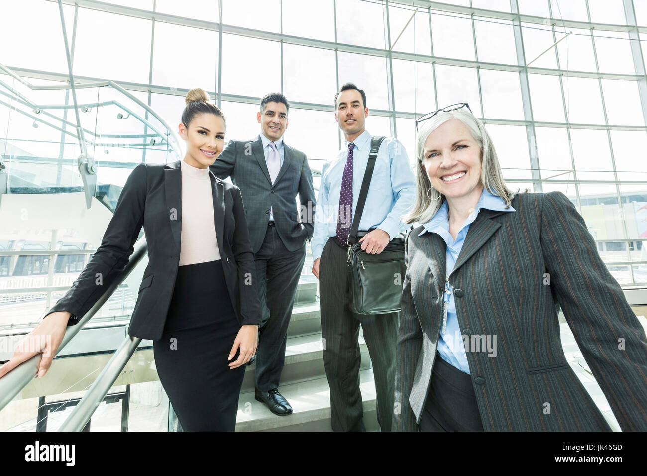 Portrait of smiling business people standing on staircase Stock Photo