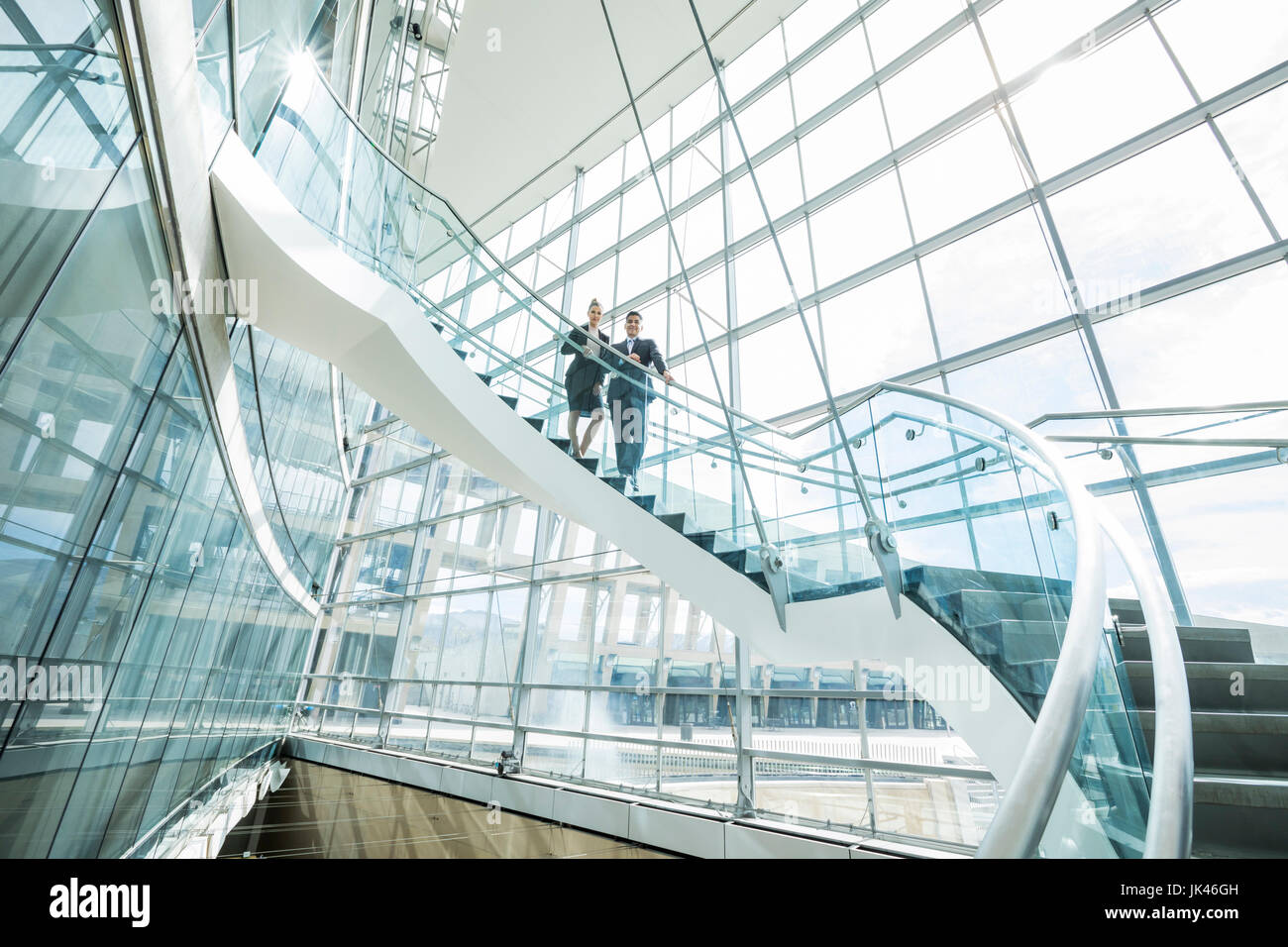 Portrait of distant Mixed Race business people standing on staircase Stock Photo