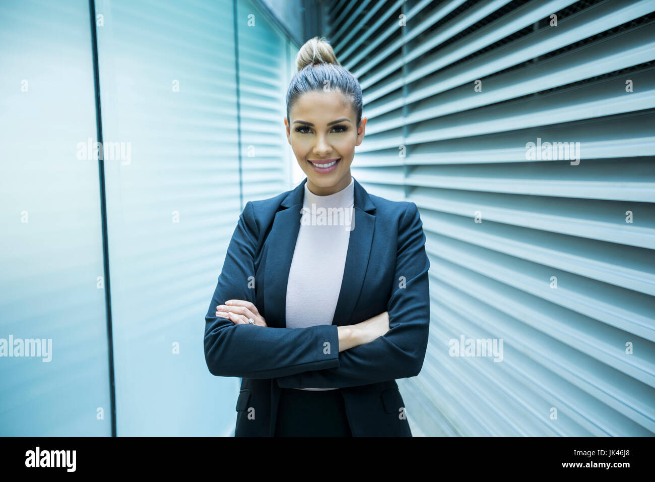 Portrait of smiling Mixed Race businesswoman in corridor Stock Photo