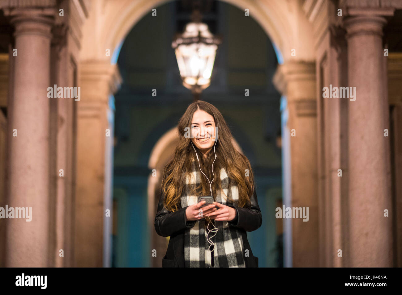 Smiling Caucasian woman listening to music on cell phone Stock Photo