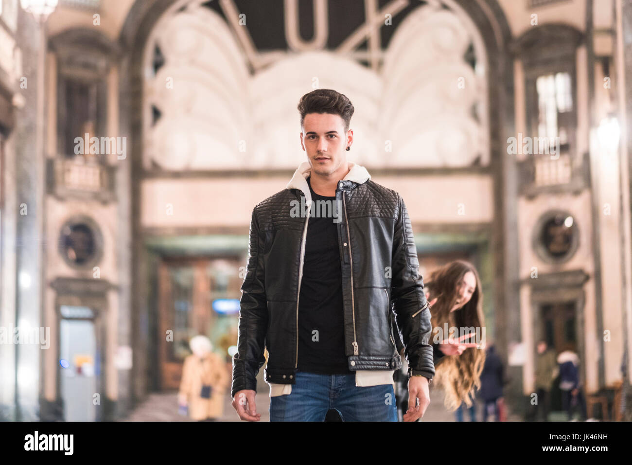 Smiling Caucasian woman gesturing behind man in lobby Stock Photo