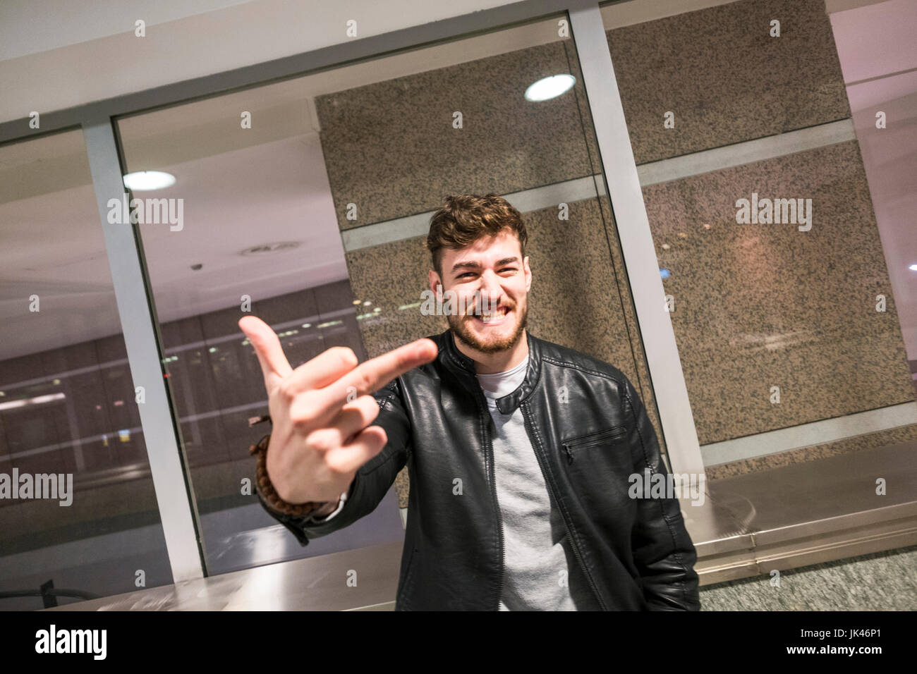 Grinning Caucasian man making obscene gesture with finger Stock Photo