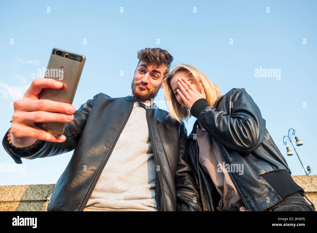 Caucasian couple posing for cell phone selfie Stock Photo