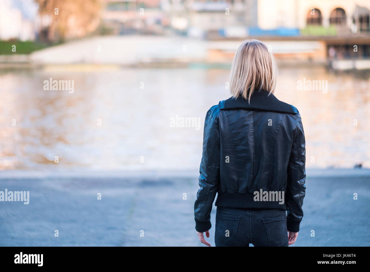 Rear view of Caucasian woman standing near river Stock Photo
