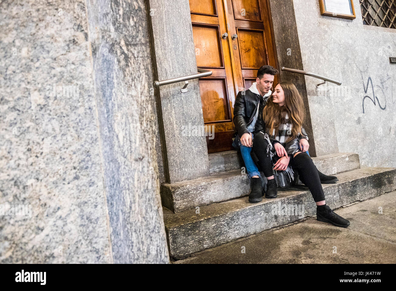 Caucasian couple sitting on concrete front stoop Stock Photo