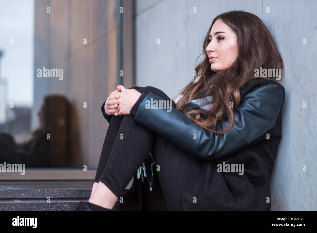 Pensive Caucasian woman sitting on staircase Stock Photo