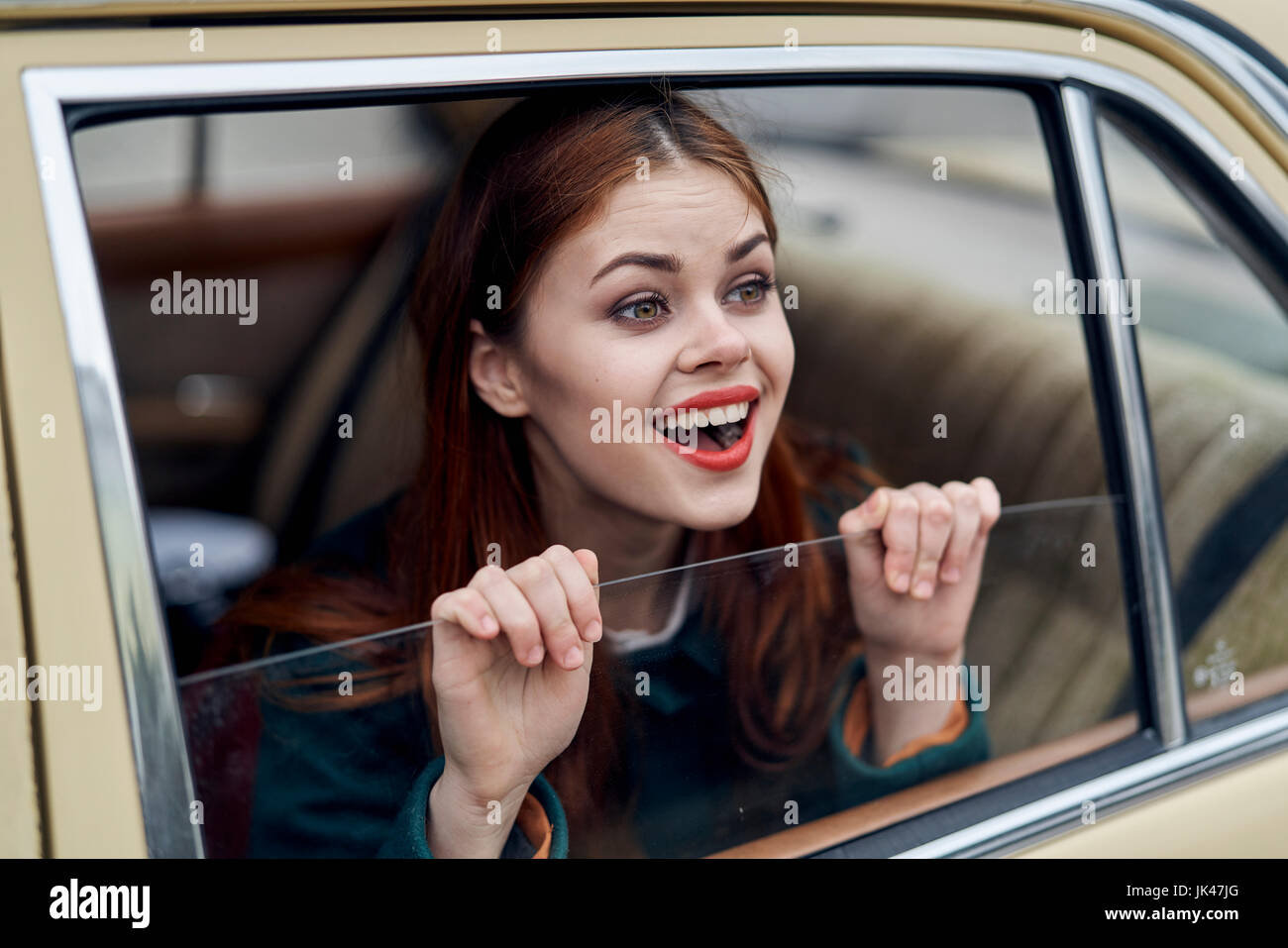 Caucasian woman smiling in back seat of car Stock Photo