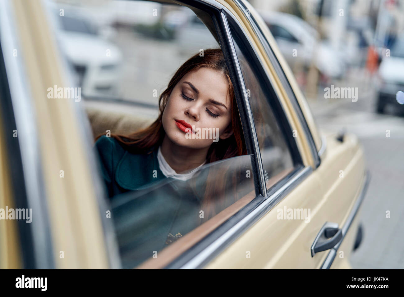 Caucasian woman sleeping in back seat of car Stock Photo