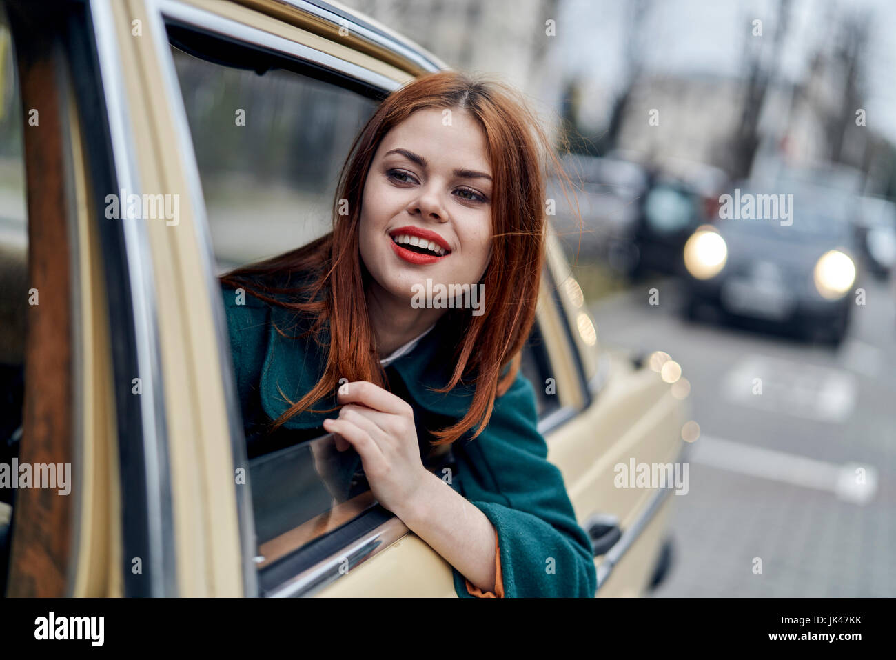 Smiling Caucasian woman in back seat of car Stock Photo