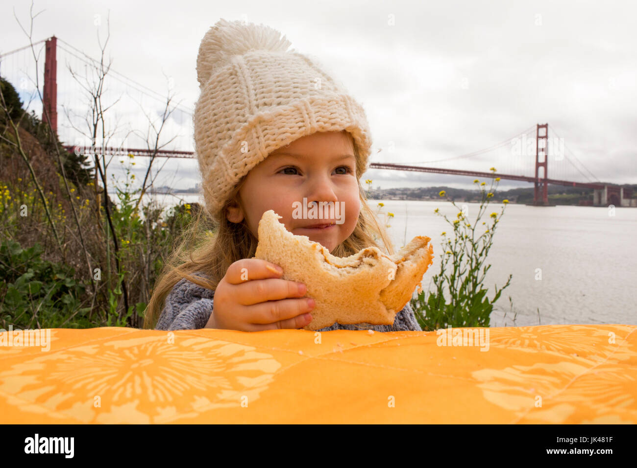 Caucasian girl eating sandwich outdoors Stock Photo