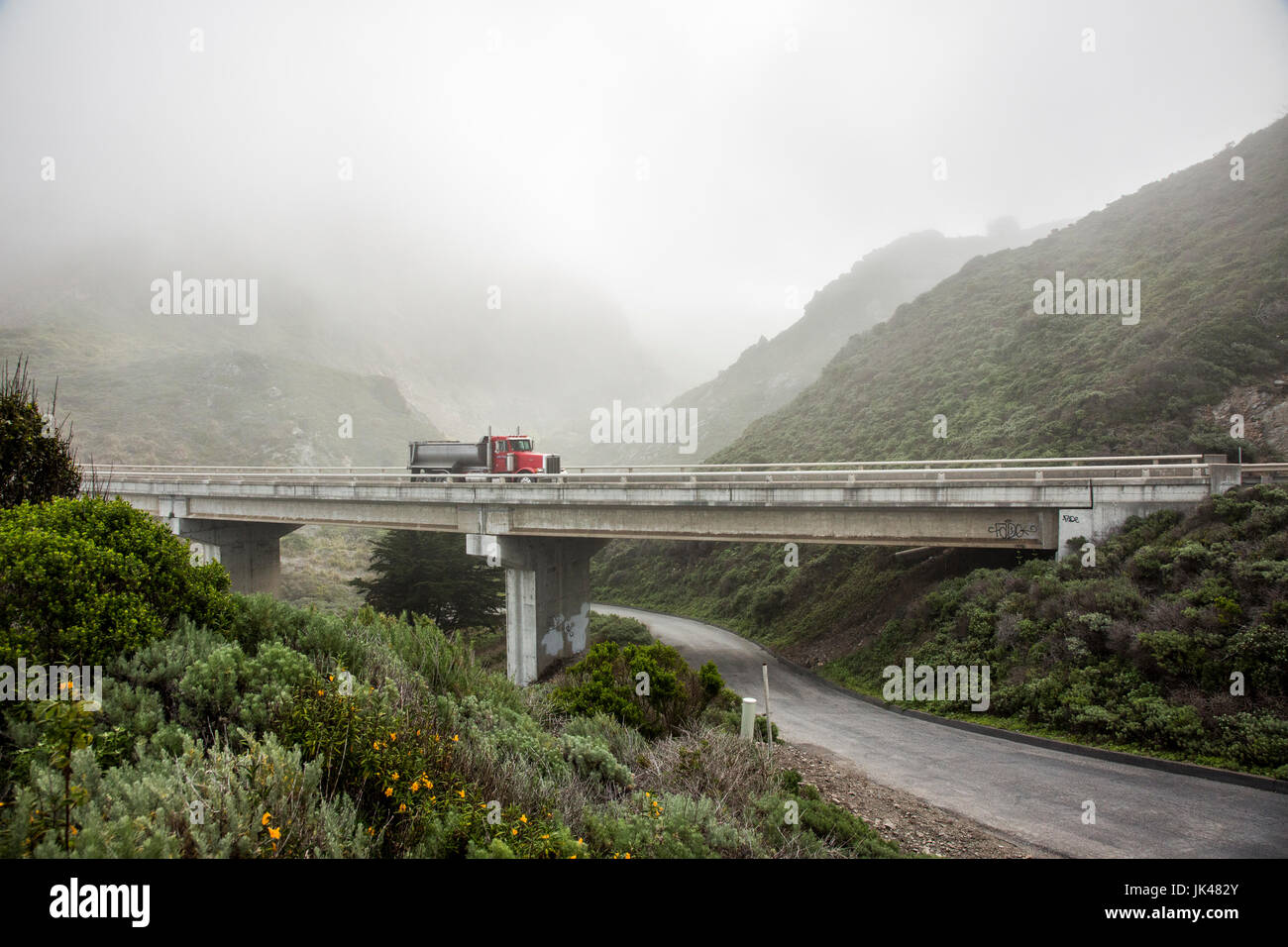 Truck driving on overpass in hills Stock Photo