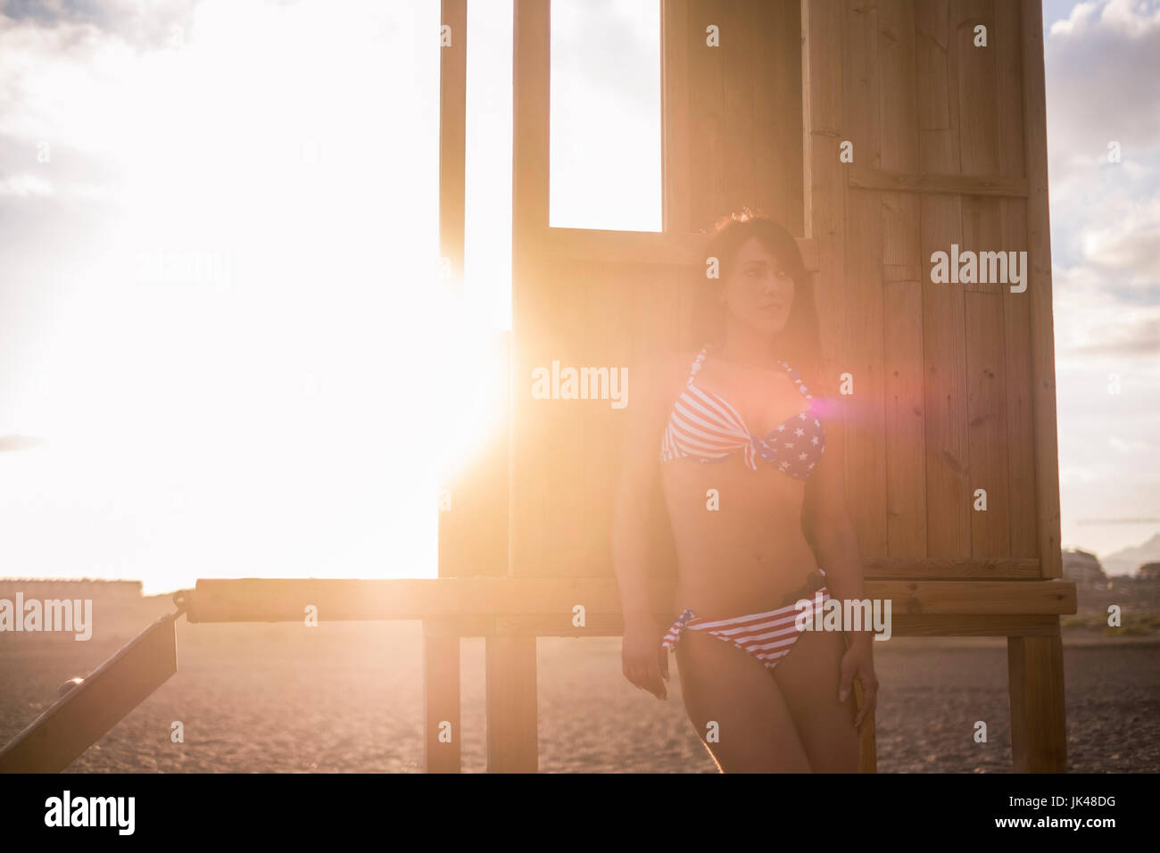Caucasian woman leaning on cabana on sunny beach Stock Photo