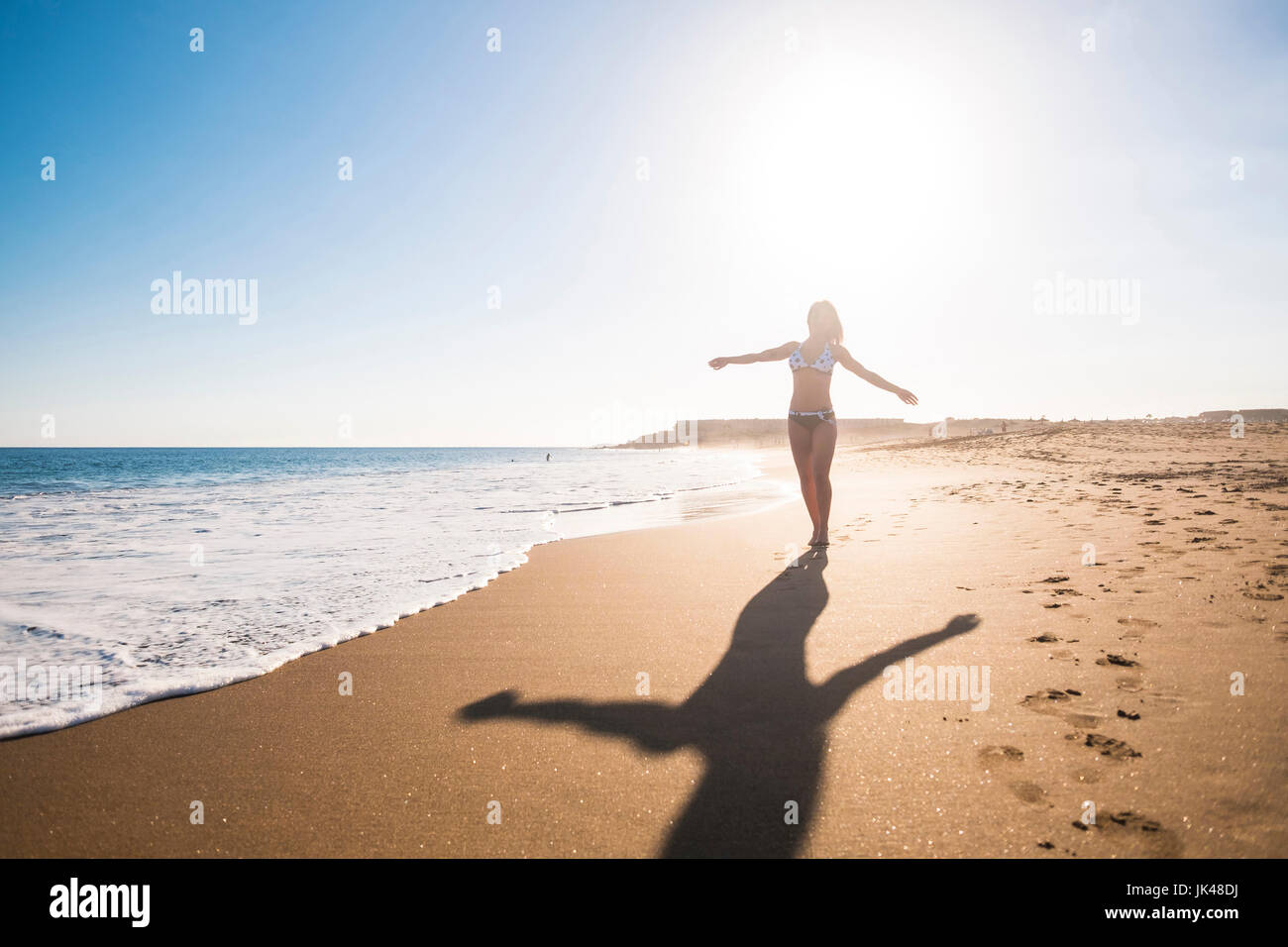 Carefree Caucasian woman walking on beach Stock Photo