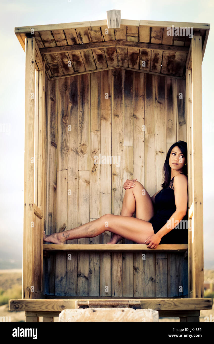 Caucasian woman sitting in cabana on beach Stock Photo