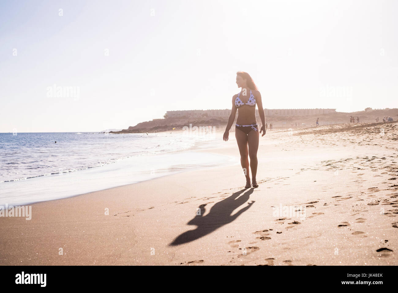 Caucasian woman walking on beach Stock Photo