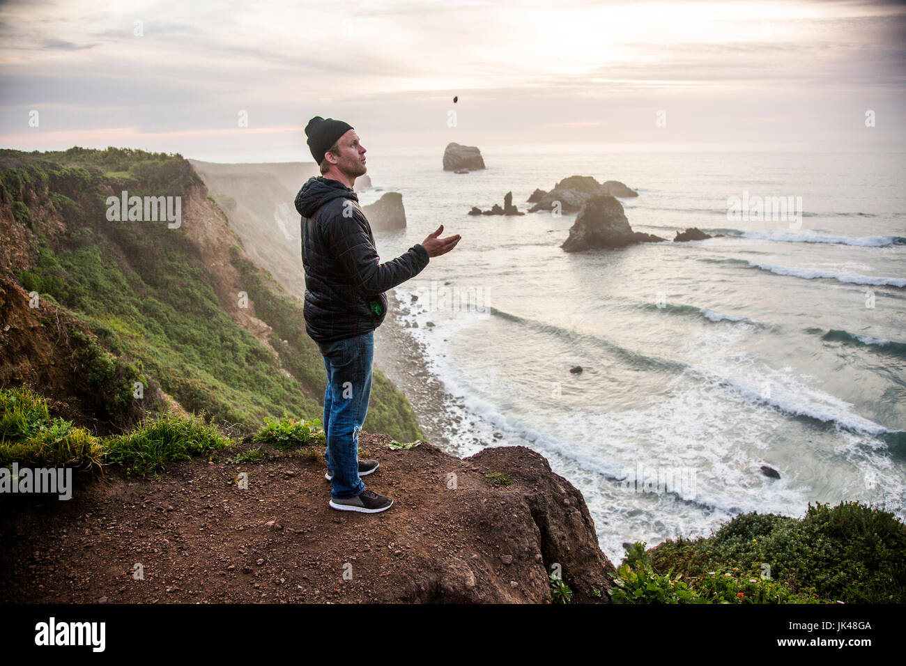 Caucasian man admiring scenic view of ocean sunset Stock Photo