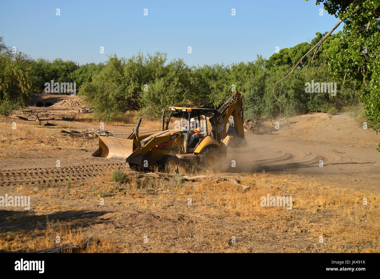 An operator of heavy equipment covers his face to protect himself from