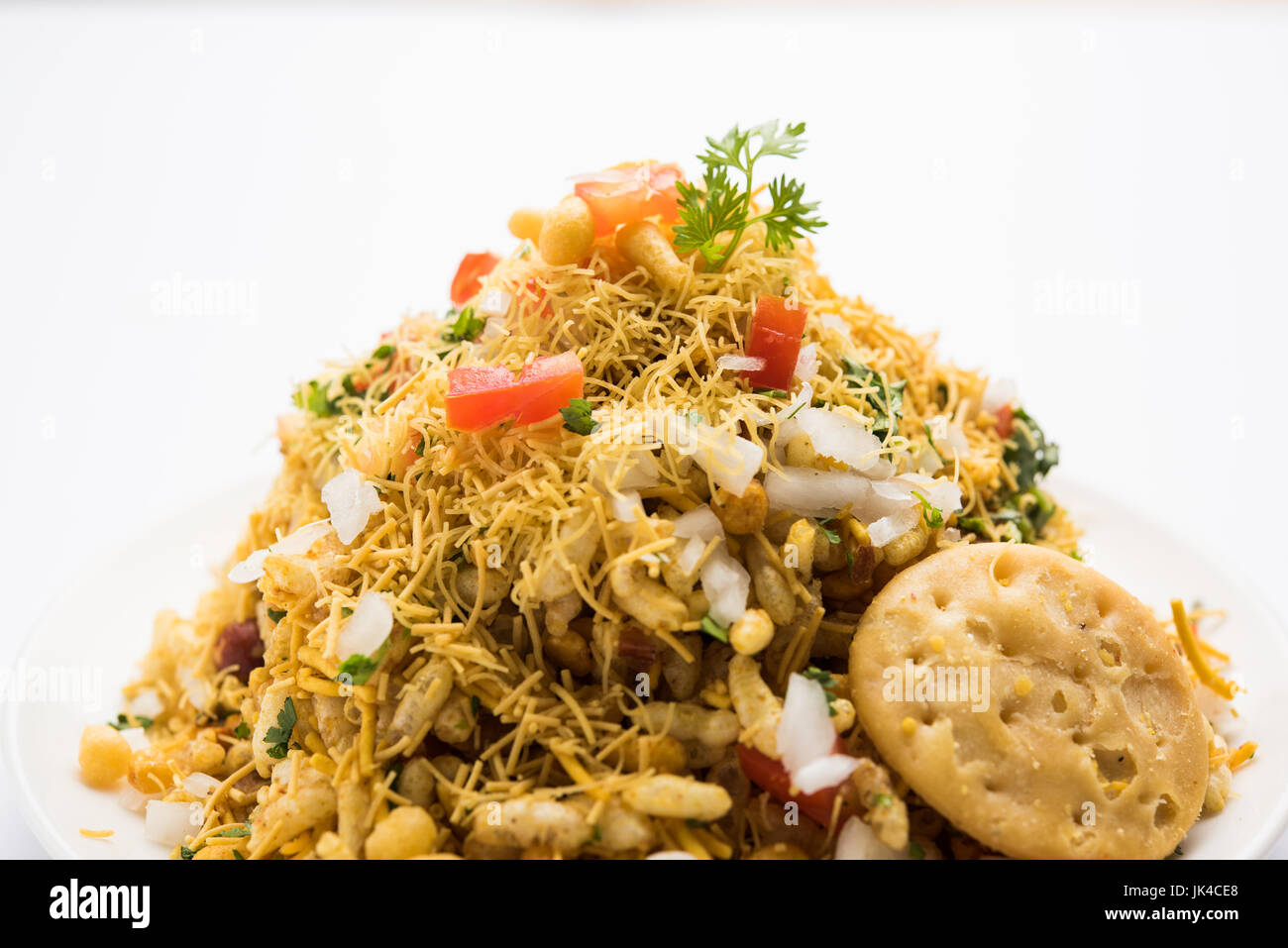 Bhel Puri - Popular Mumbai street food served with coriander and tamarind chutney on white background, selective focus Stock Photo