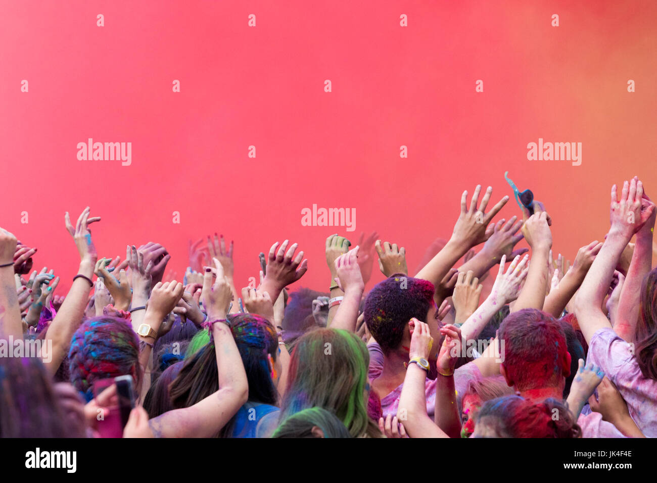 People enjoying colorful powder party in a red cloud in Renteria ...