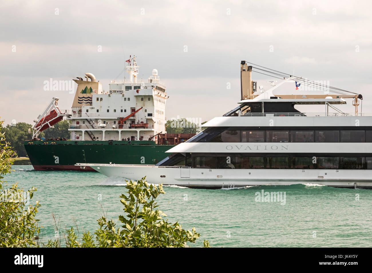 Detroit, Michigan - The Ovation, a luxury charter yacht, passes the Bluewing, a Great Lake bulk cargo vessel, on the Detroit River. Stock Photo