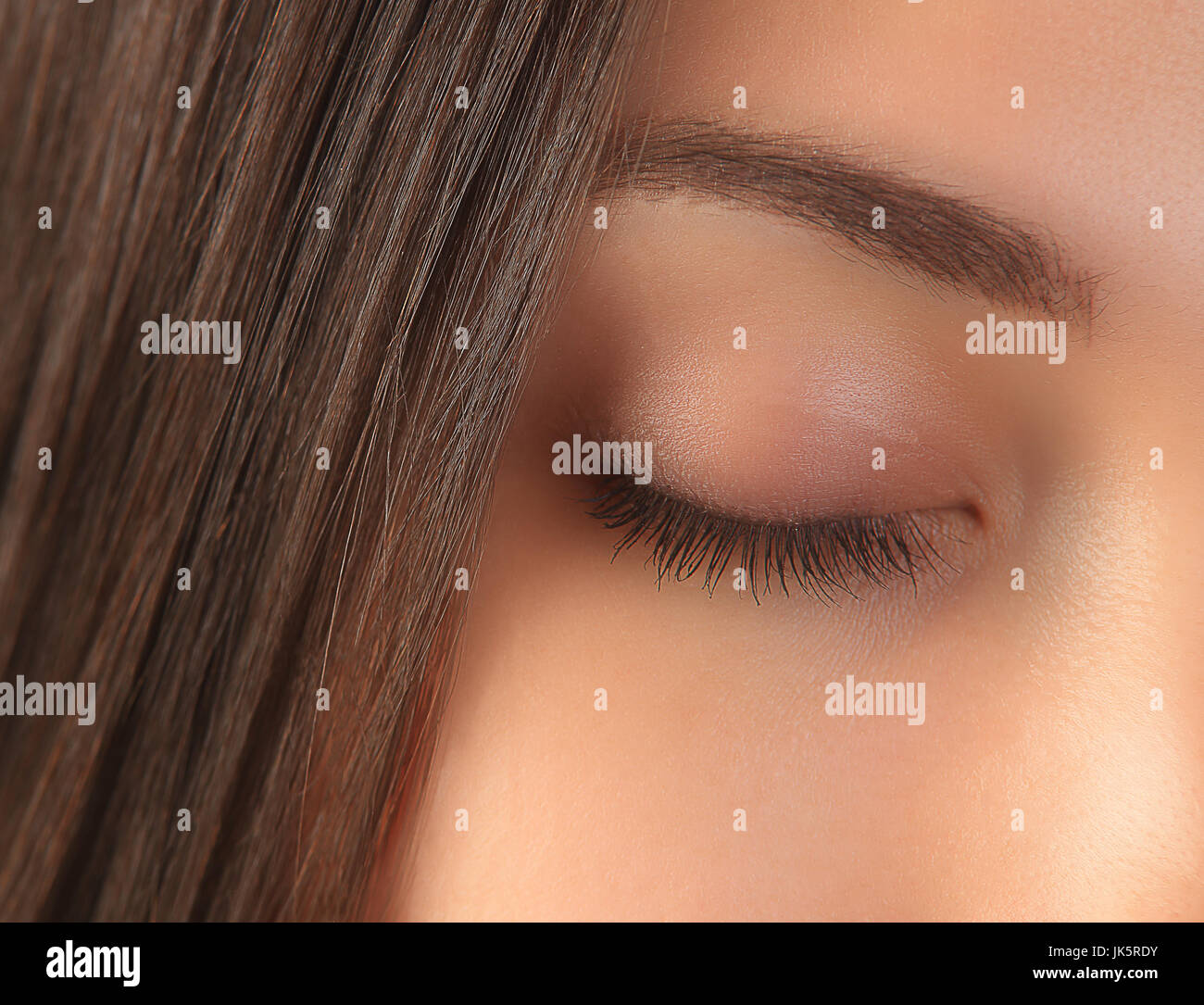Closed girl eye close-up. Woman face with clean perfect skin. Brunette girl face with smooth skin closeup. Stock Photo