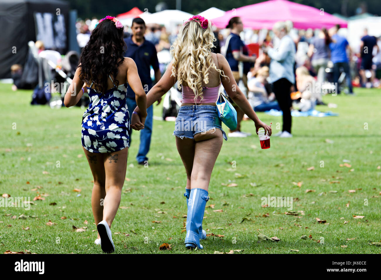 Girls arriving in wellies and cut off shorts for the Liverpool International Music Festival in Liverpool Merseyside UK. Stock Photo