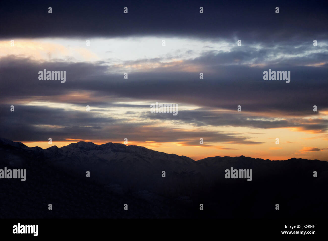 Sunrise coming over a mountain with clouds Stock Photo - Alamy