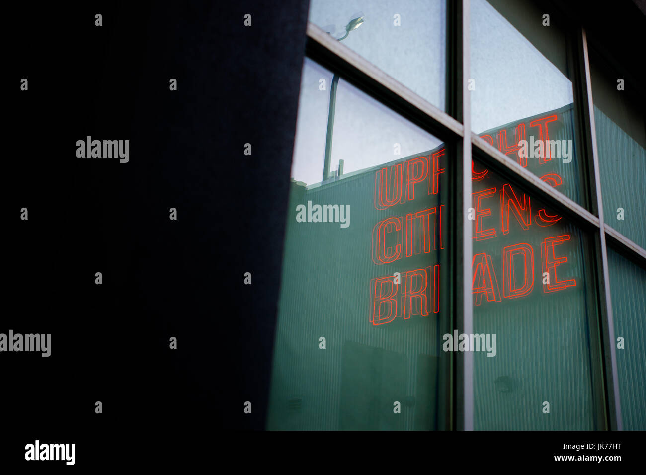 Upright Citizens Brigade sign reflected in window at dusk, in Hollywood, Los Angeles California. Stock Photo